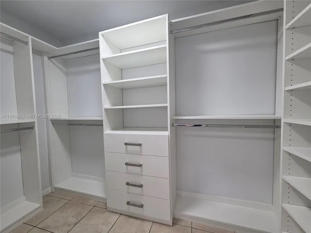 a view of walk in closet with empty racks