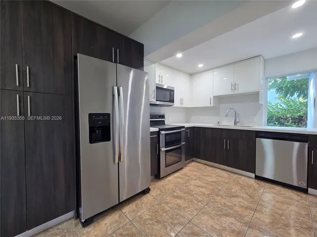 a kitchen with stainless steel appliances a refrigerator sink and cabinets