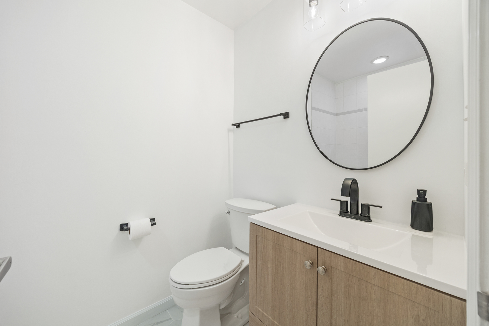 2106 West Erie Street, Unit 1E Chicago, IL 60612 - Photo 12 of 41 a bathroom with a sink a mirror a toilet and a sink