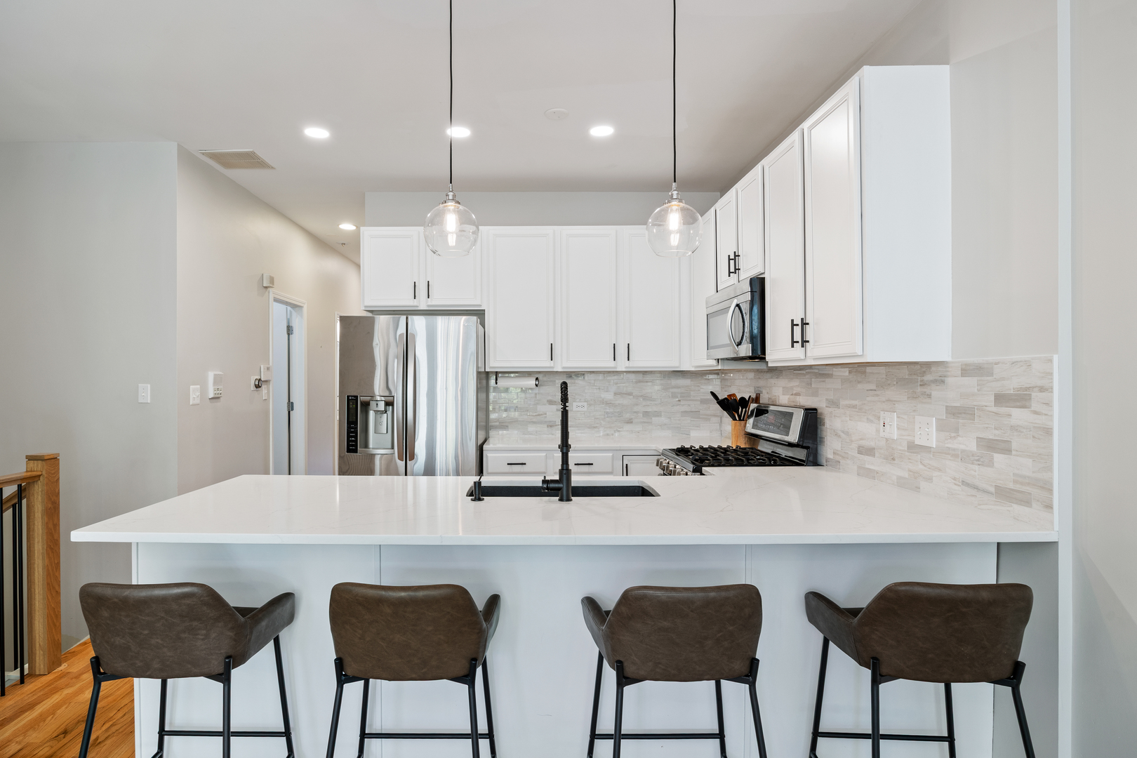 2106 West Erie Street, Unit 1E Chicago, IL 60612 - Photo 7 of 41 a kitchen with stainless steel appliances granite countertop a kitchen island and chairs in it
