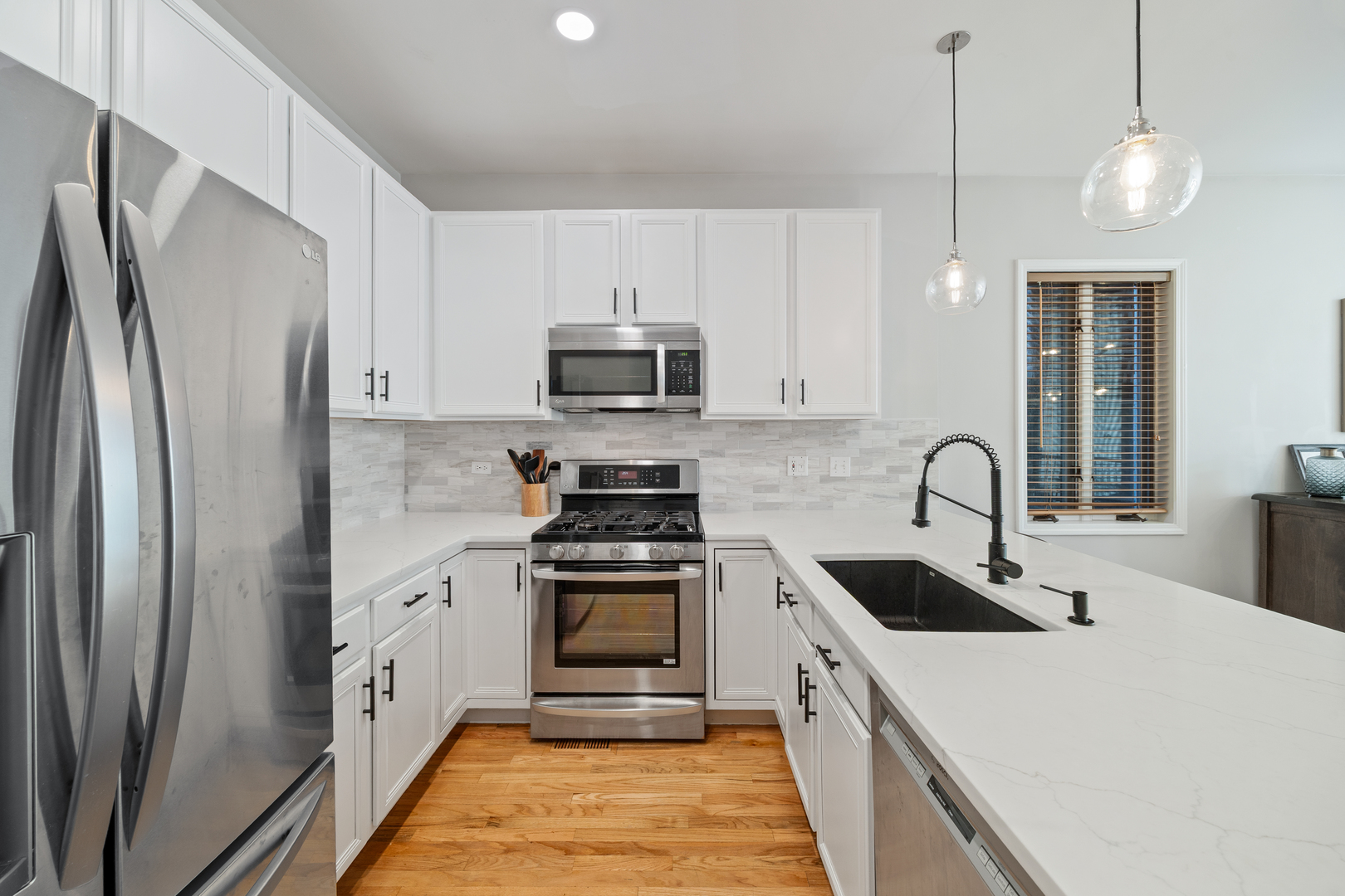2106 West Erie Street, Unit 1E Chicago, IL 60612 - Photo 8 of 41 a kitchen with stainless steel appliances a refrigerator sink and white cabinets