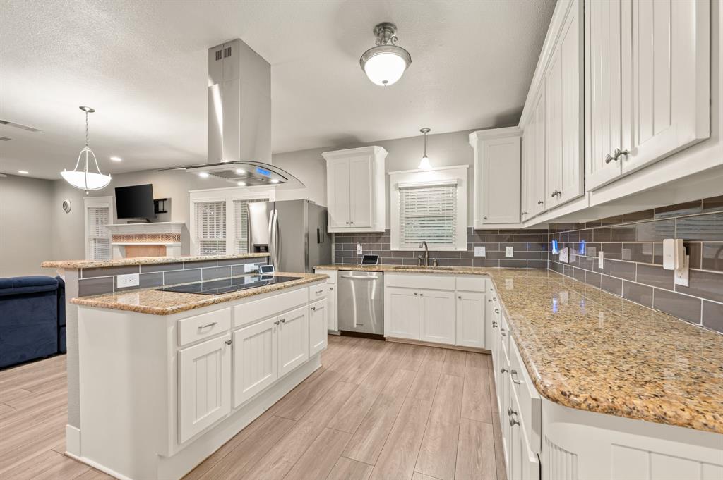 800 North Clements Street Gainesville, TX 76240 - Photo 11 of 27 a kitchen with stainless steel appliances granite countertop a stove oven and white cabinets