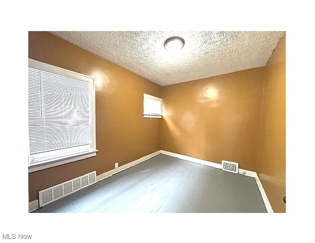 13436-13438 Hartford Road Cleveland, OH 44112 - Photo 5 of 5 Unfurnished room with a textured ceiling and wood finished floors