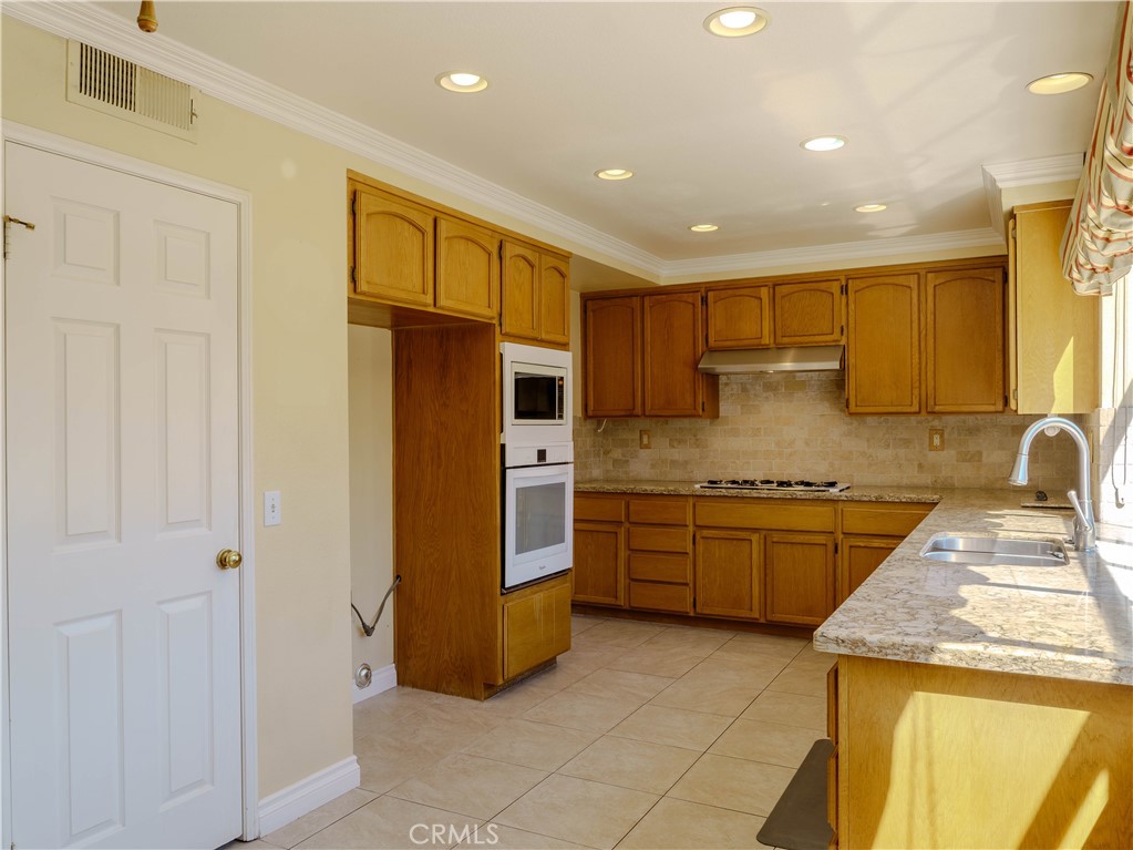 6853 Pandino Court Rancho Cucamonga, CA 91701 - Photo 12 of 44 a kitchen with stainless steel appliances granite countertop a refrigerator and a stove top oven