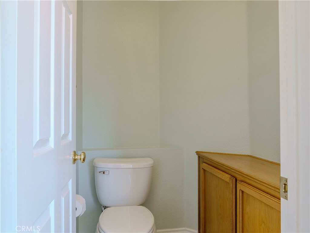 6853 Pandino Court Rancho Cucamonga, CA 91701 - Photo 22 of 44 a white toilet sitting next to a shower curtain