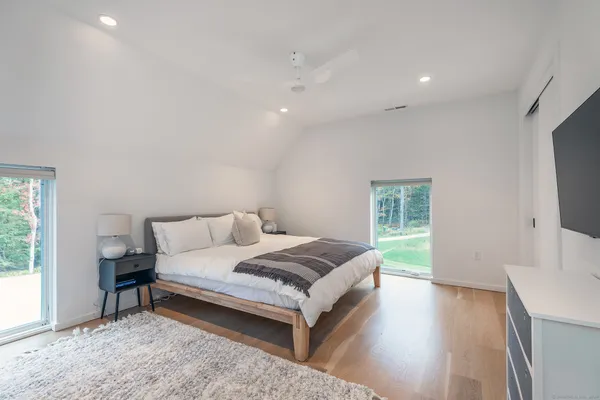 a spacious bedroom with a bed and a flat screen television