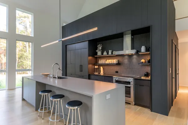 a kitchen with a sink a stove and chairs