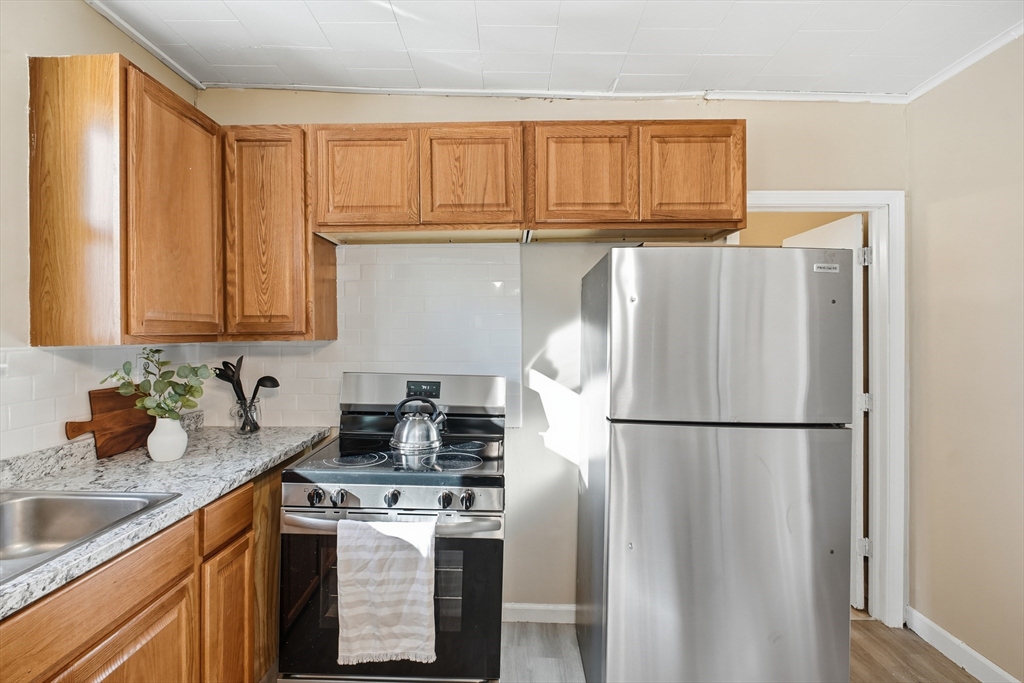 51-53 Abbe Avenue Springfield, MA 01107 - Photo 15 of 42 a kitchen with stainless steel appliances granite countertop a refrigerator sink and cabinets