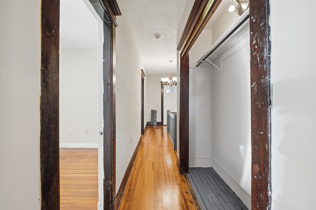 51-53 Abbe Avenue Springfield, MA 01107 - Photo 23 of 42 a view of a hallway with wooden floor and a bathroom