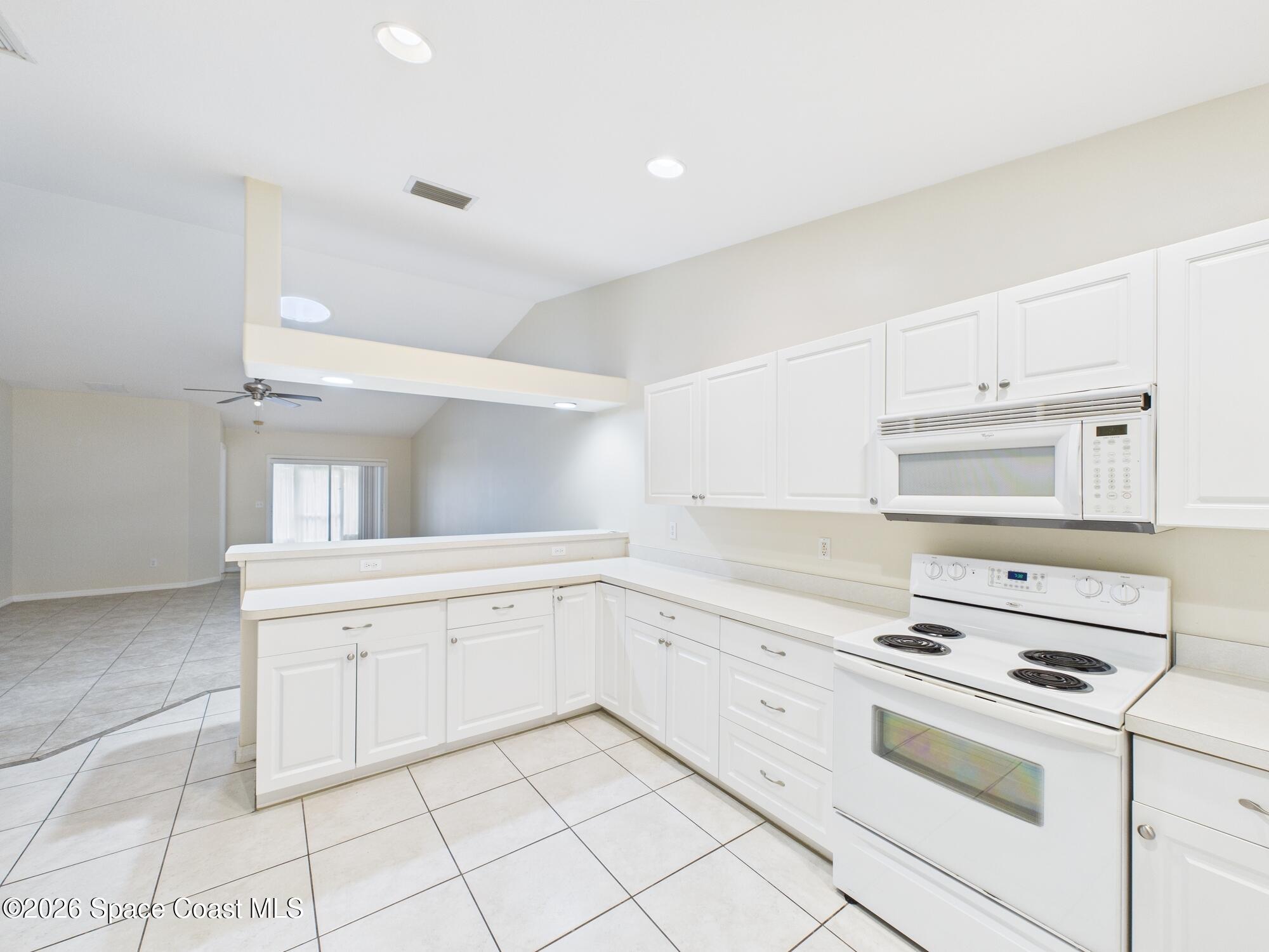 131 Maggie Way Sebastian, FL 32958 - Photo 5 of 19 a kitchen with granite countertop white cabinets and white appliances