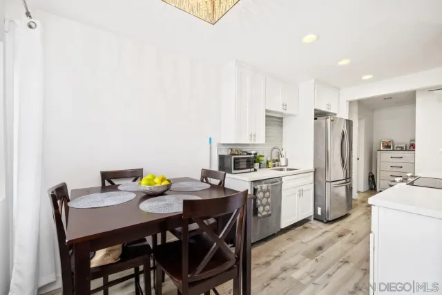 a kitchen with a dining table chairs and refrigerator