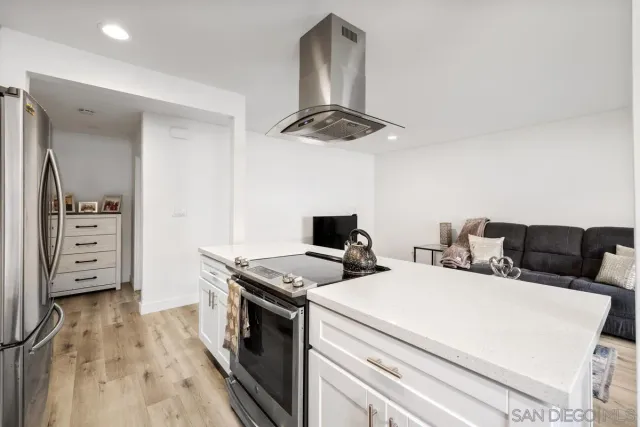 a kitchen that has a stove and a wooden floor