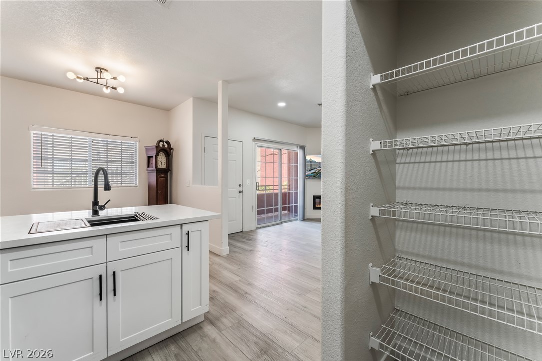 4730 East Craig Road, Unit 1058 Las Vegas, NV 89115 - Photo 14 of 30 A well-equipped kitchen island with sink connects to an open-concept living space with sliding glass doors.