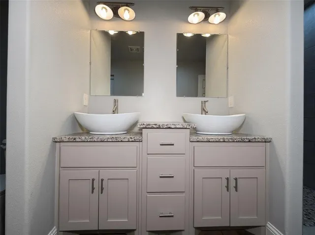 a bathroom with a sink vanity and mirror
