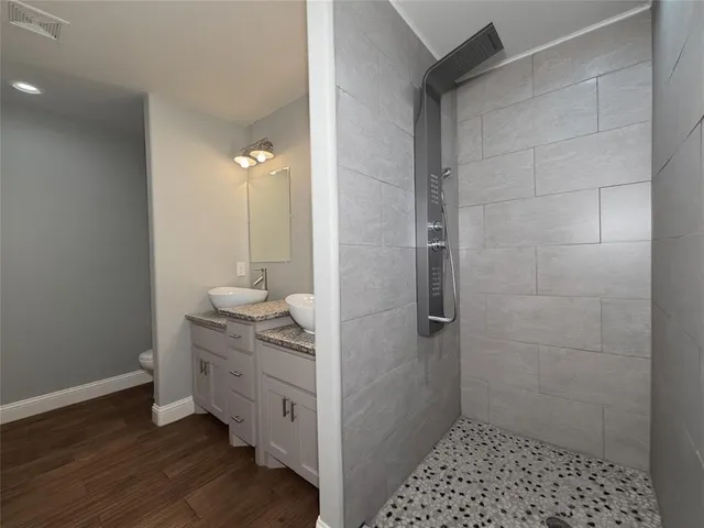 a bathroom with a sink a toilet and shower