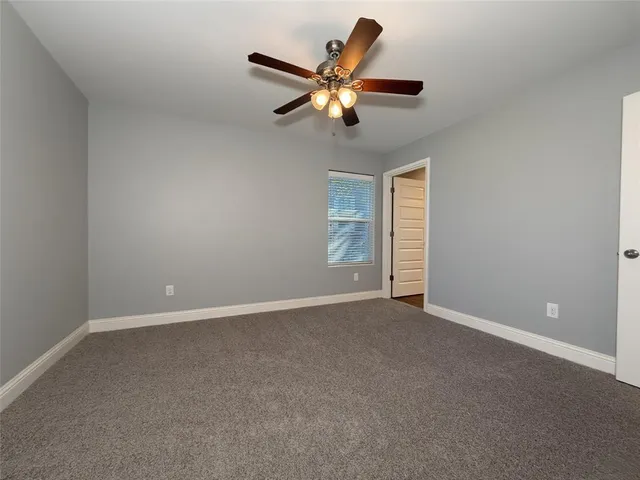 a view of an empty room with a ceiling fan