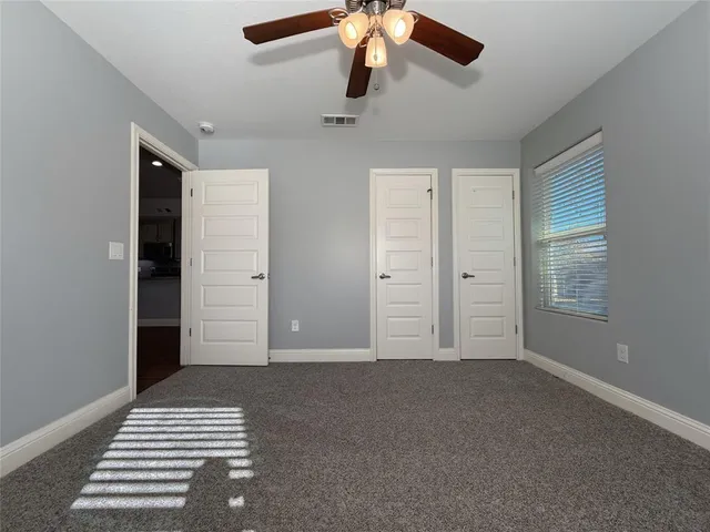 an empty room with closet and windows