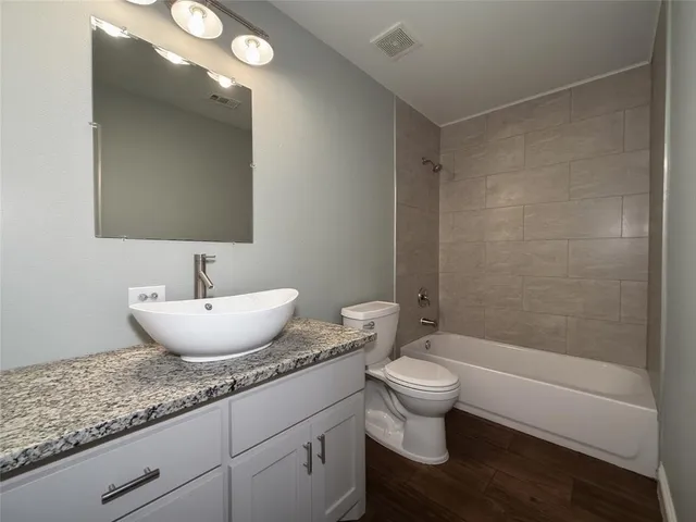 a bathroom with a granite countertop sink toilet and shower
