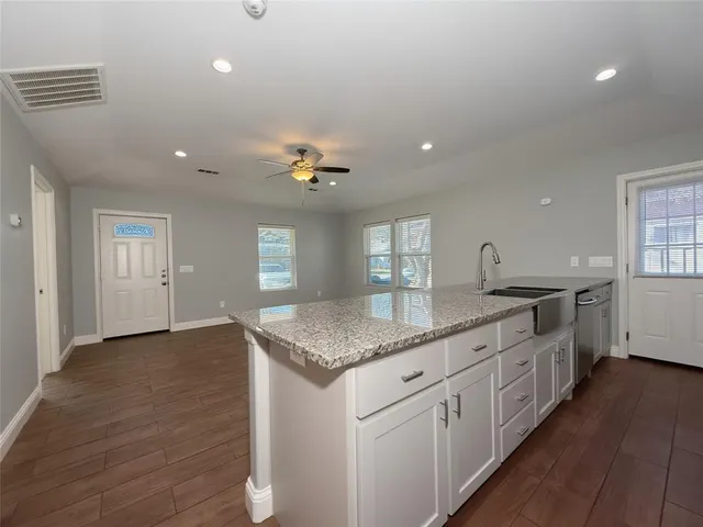 a kitchen with granite countertop white cabinets and window