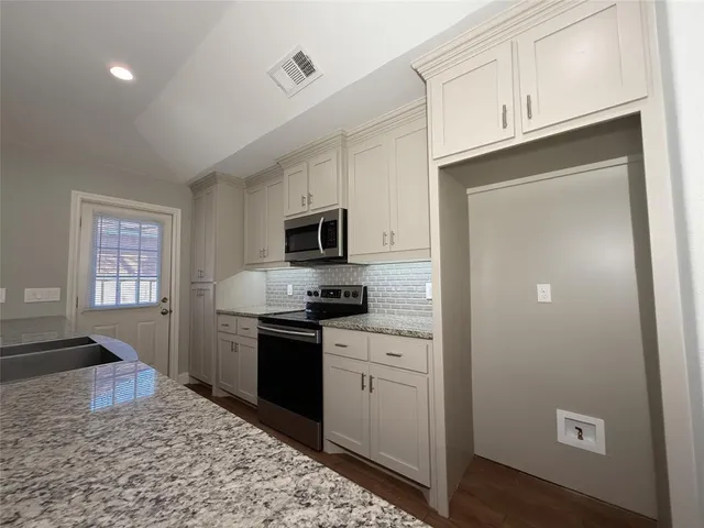 a kitchen with stainless steel appliances granite countertop a refrigerator sink and stove