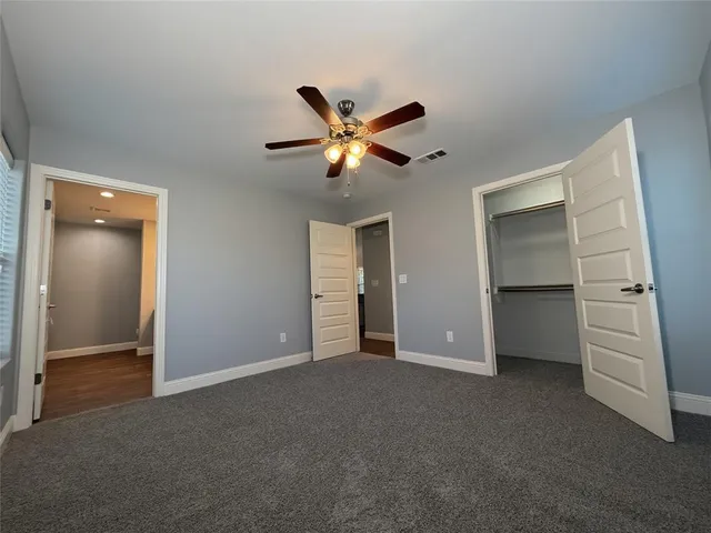 a view of an empty room with a ceiling fan