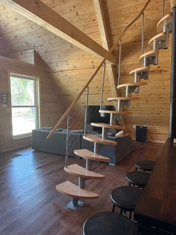a backyard of a house with wooden table and chairs
