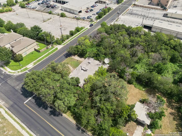 an aerial view of a house with a yard and large trees