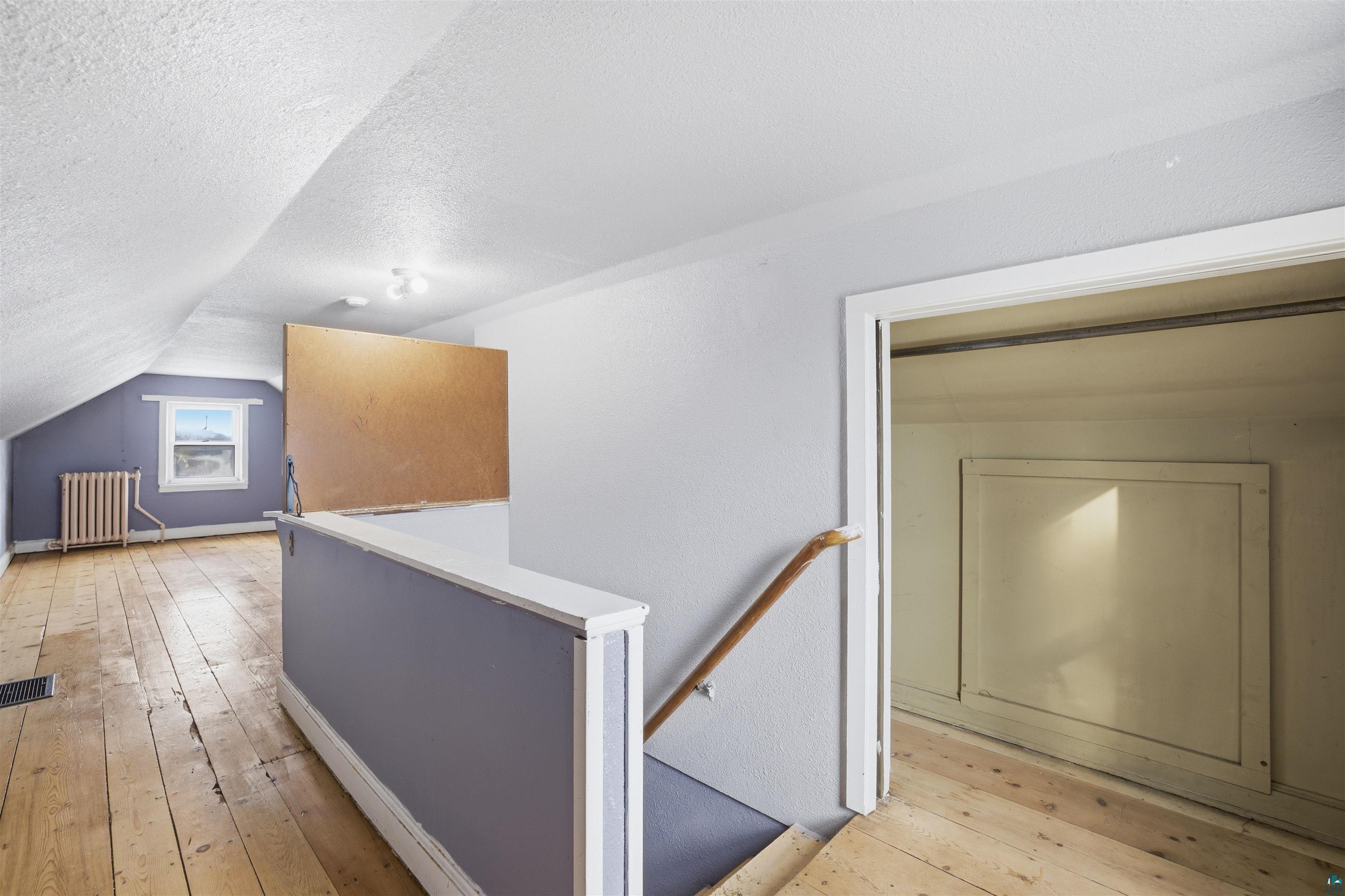726 Summit Street Eveleth, MN 55734 - Photo 16 of 29 Hallway with an upstairs landing, light wood finished floors, and radiator heating unit