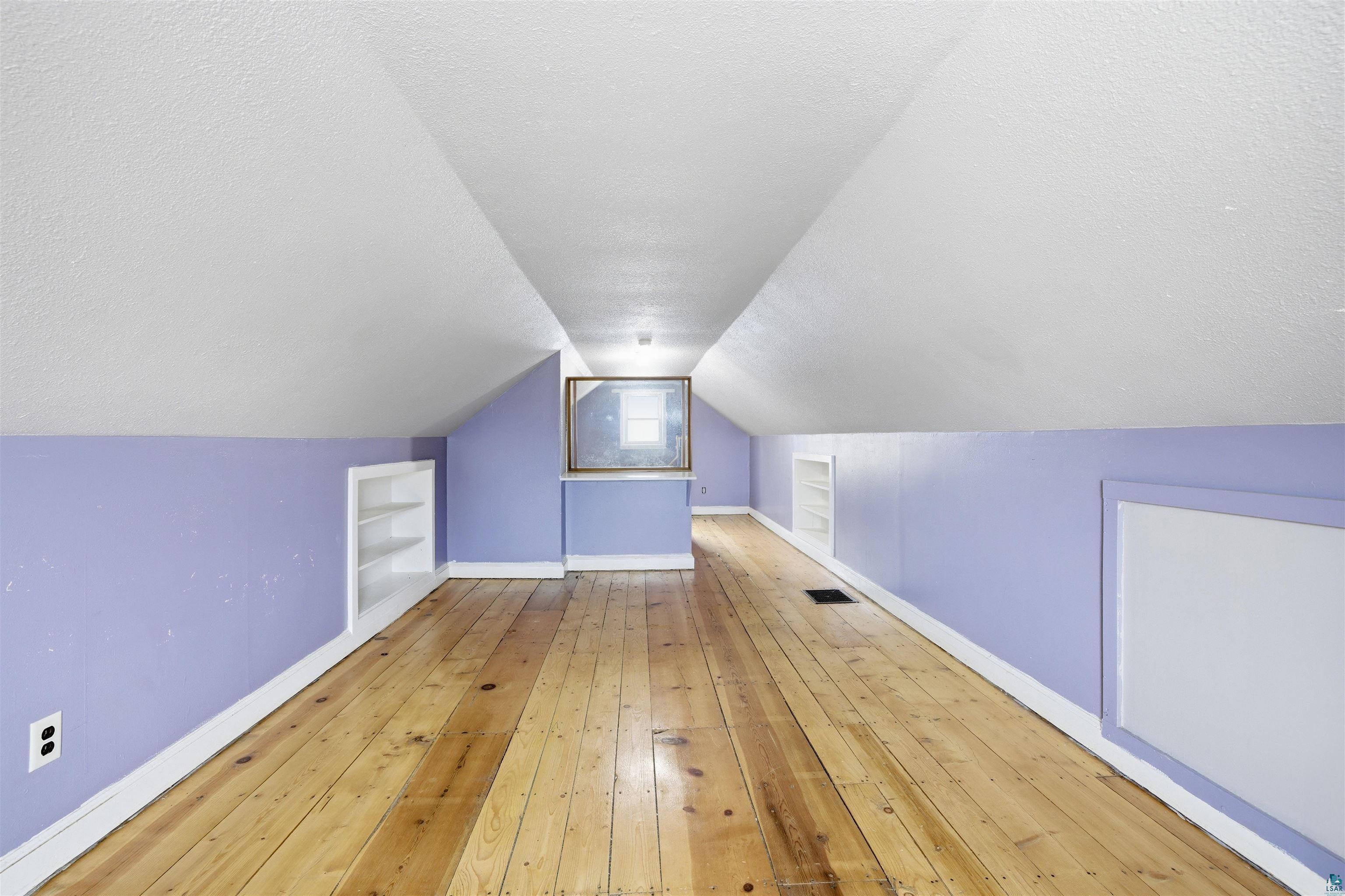 726 Summit Street Eveleth, MN 55734 - Photo 18 of 29 Additional living space featuring light wood-style flooring, built in features, and a textured ceiling