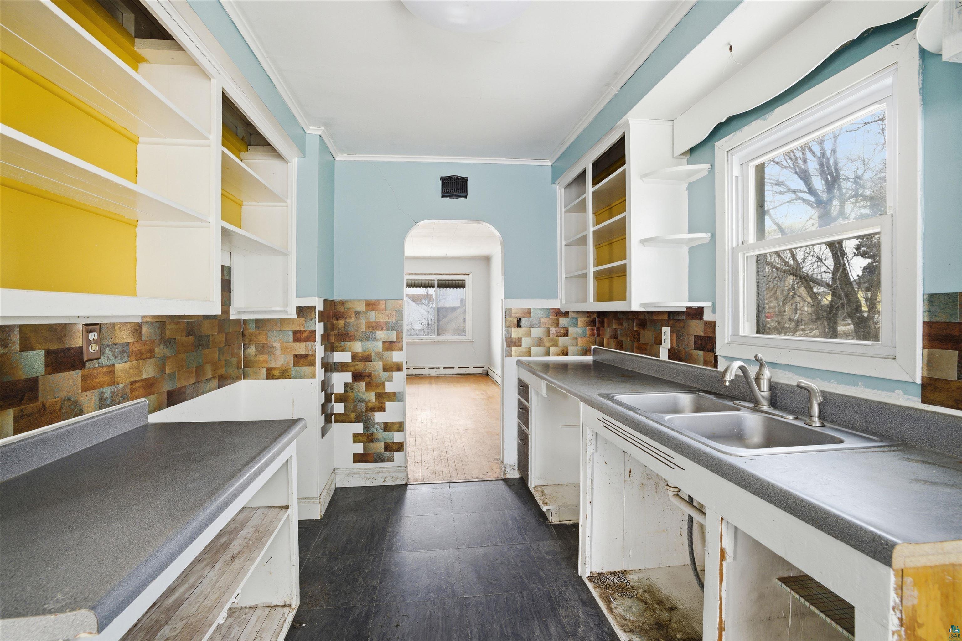726 Summit Street Eveleth, MN 55734 - Photo 7 of 29 Kitchen featuring open shelves, white cabinetry, ornamental molding, arched walkways, and dark countertops
