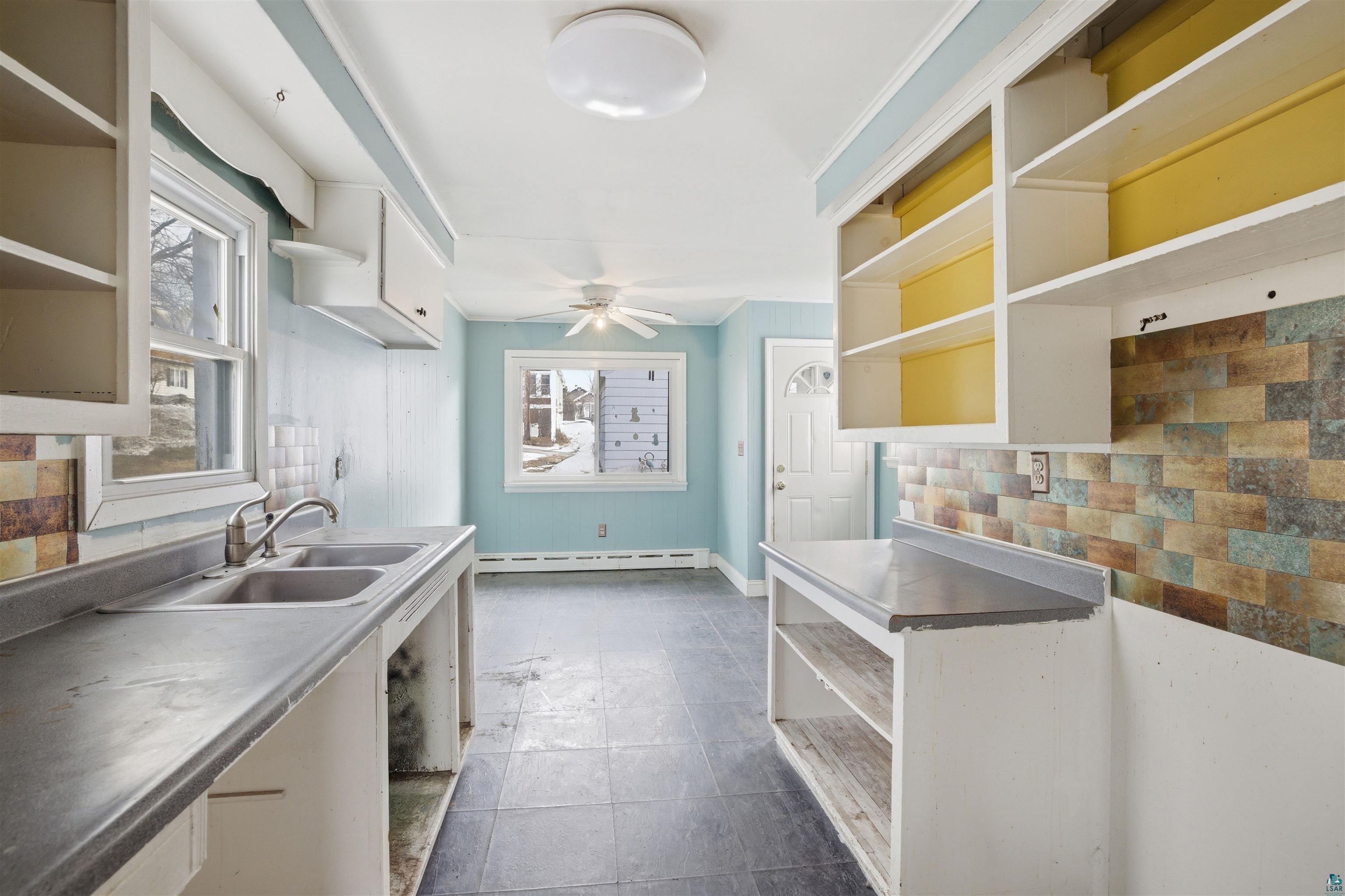 726 Summit Street Eveleth, MN 55734 - Photo 8 of 29 Kitchen with open shelves, plenty of natural light, and decorative backsplash