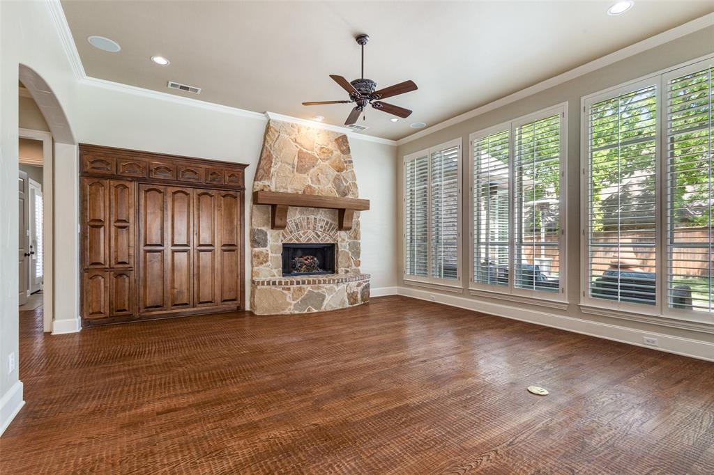 901 Sandy Trail Keller, TX 76248 - Photo 12 of 36 Unfurnished living room with ceiling fan, arched walkways, crown molding, a stone fireplace, and recessed lighting