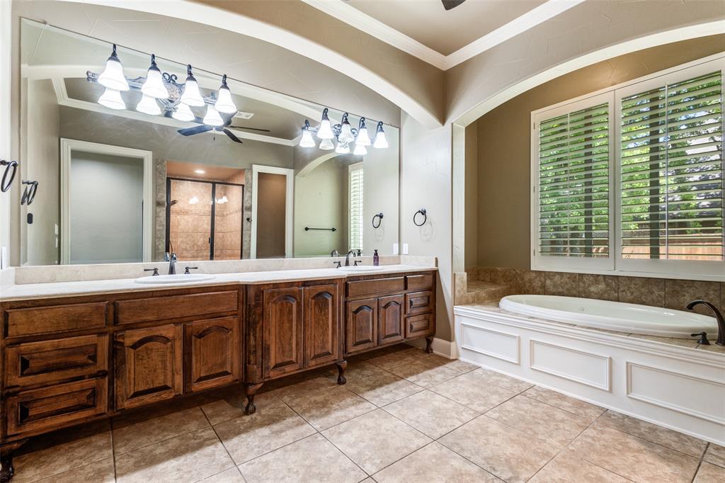 901 Sandy Trail Keller, TX 76248 - Photo 22 of 36 Bathroom with ceiling fan, crown molding, double vanity, a stall shower, and a garden tub