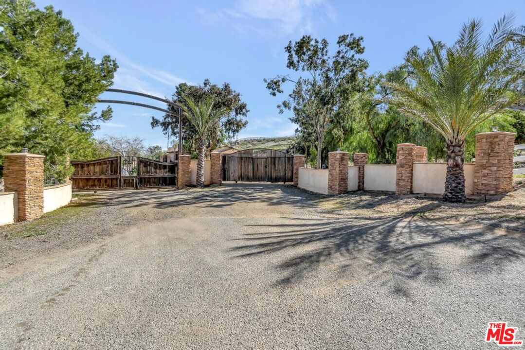a view of a house with a yard and potted plants
