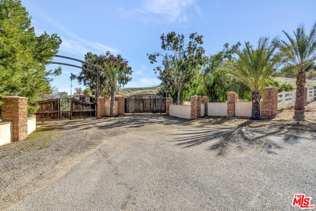 11455 Pigeon Pass Road Moreno Valley, CA 92557 - Photo 2 of 48 a front view of a house with a yard and a garage