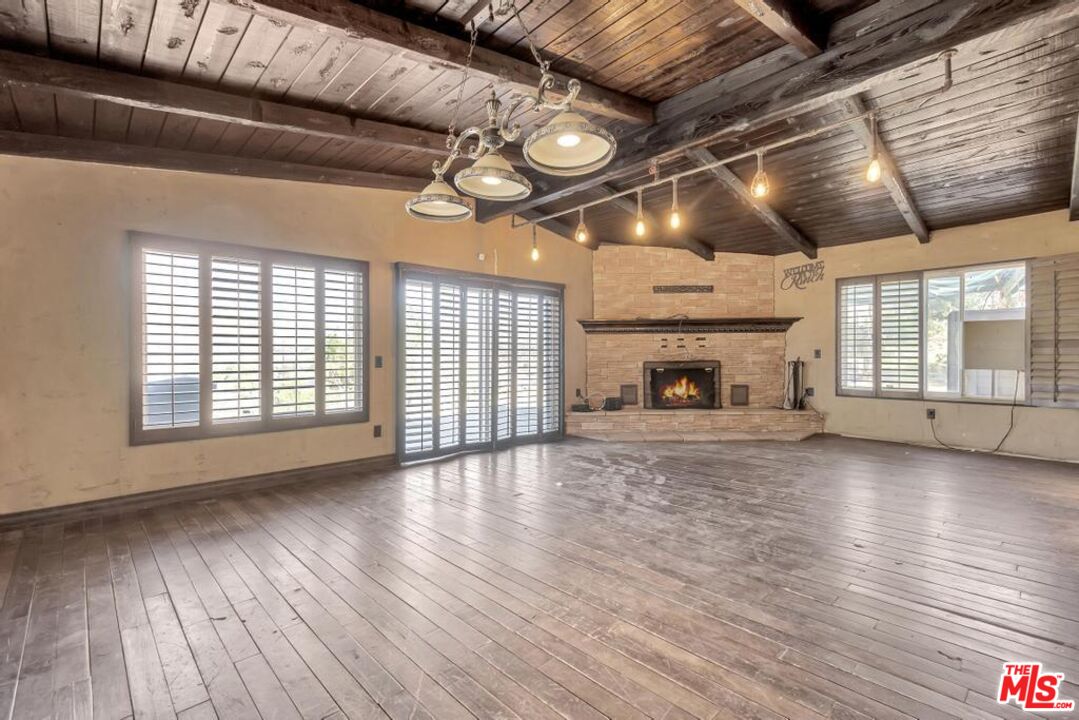 11455 Pigeon Pass Road Moreno Valley, CA 92557 - Photo 23 of 48 a view of empty room with wooden floor and fireplace