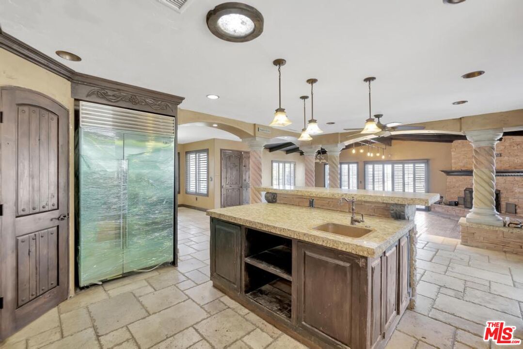 11455 Pigeon Pass Road Moreno Valley, CA 92557 - Photo 28 of 48 a kitchen with kitchen island granite countertop a sink and a stove