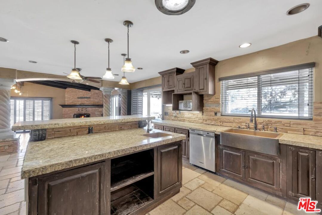 11455 Pigeon Pass Road Moreno Valley, CA 92557 - Photo 29 of 48 a kitchen with stainless steel appliances granite countertop stove a sink and a microwave