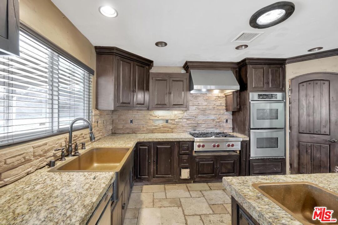 11455 Pigeon Pass Road Moreno Valley, CA 92557 - Photo 30 of 48 a kitchen with stainless steel appliances granite countertop a sink stove and refrigerator