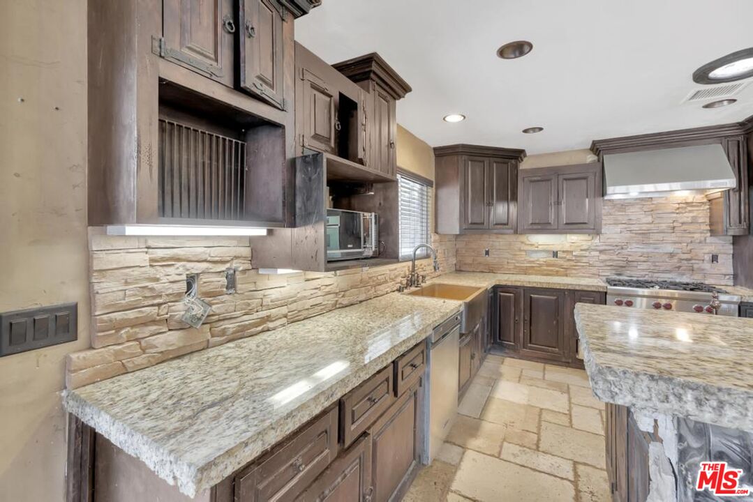 11455 Pigeon Pass Road Moreno Valley, CA 92557 - Photo 31 of 48 a kitchen with stainless steel appliances granite countertop a sink stove and granite counter tops