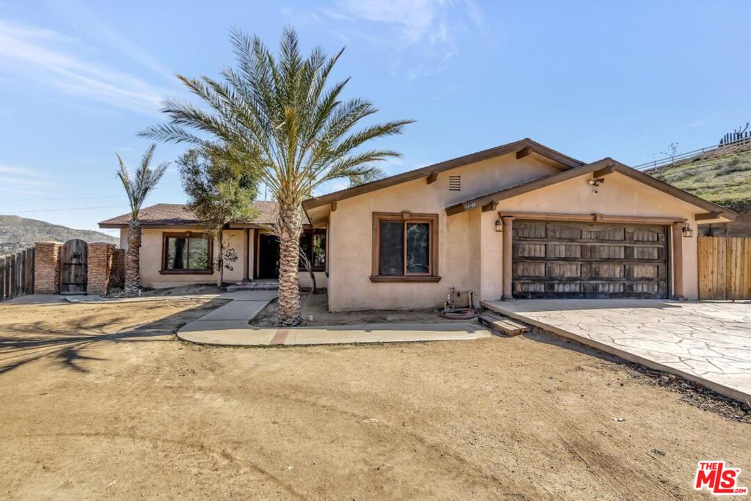 11455 Pigeon Pass Road Moreno Valley, CA 92557 - Photo 4 of 48 a front view of a house with a garden and entryway