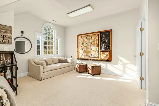 a living room with furniture kitchen view and a flat screen tv