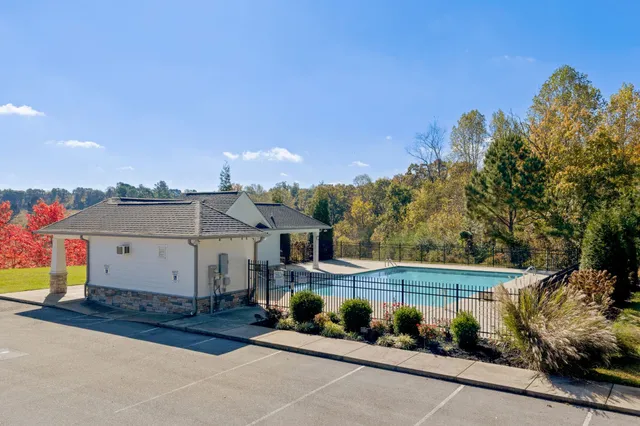 a view of swimming pool with lawn chairs and potted plants