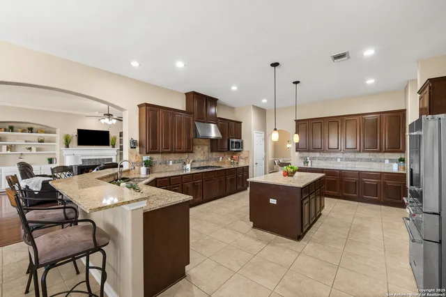 a kitchen with stainless steel appliances granite countertop a sink a stove and a refrigerator