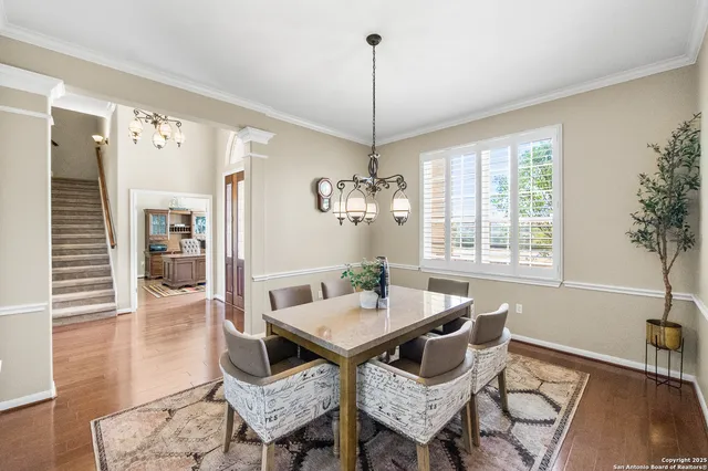 a bedroom with a bed a chair and potted plant on the dresser