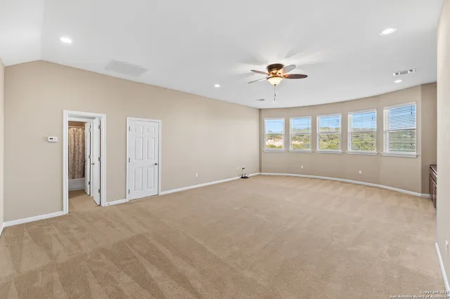 an empty room with a ceiling fan and a window