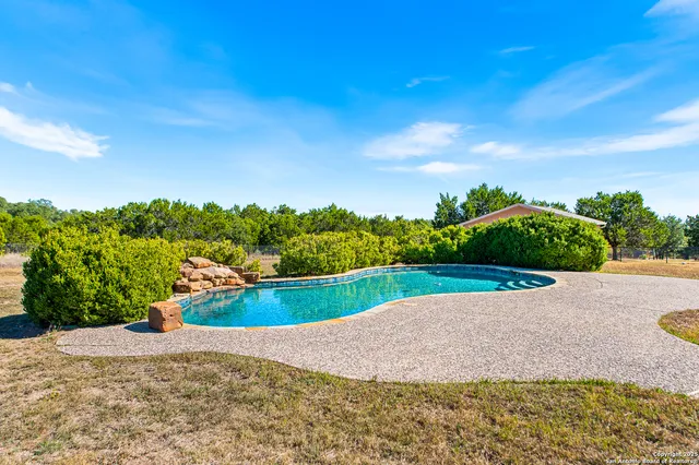 a view of a house with swimming pool and a yard