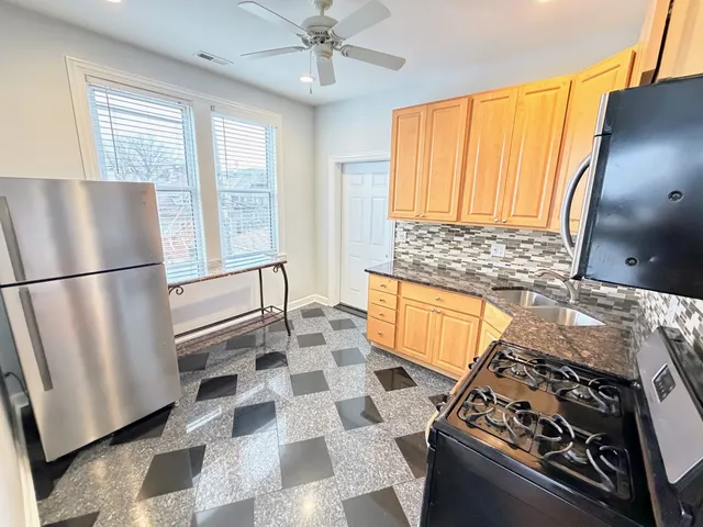 a kitchen with stainless steel appliances granite countertop a sink stove and refrigerator