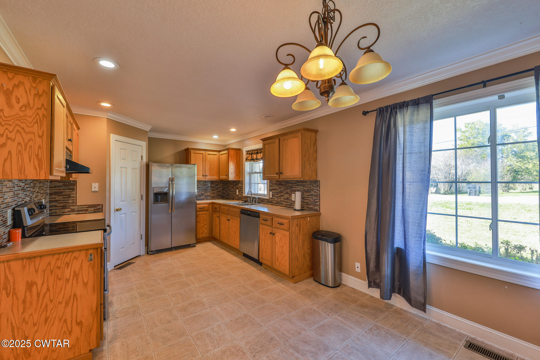 707 North Main Street Dyer, TN 38330 - Photo 15 of 29 a kitchen with stainless steel appliances granite countertop a sink a stove and a refrigerator