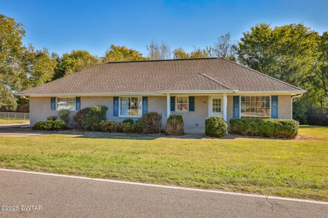 a front view of a house with a garden and yard